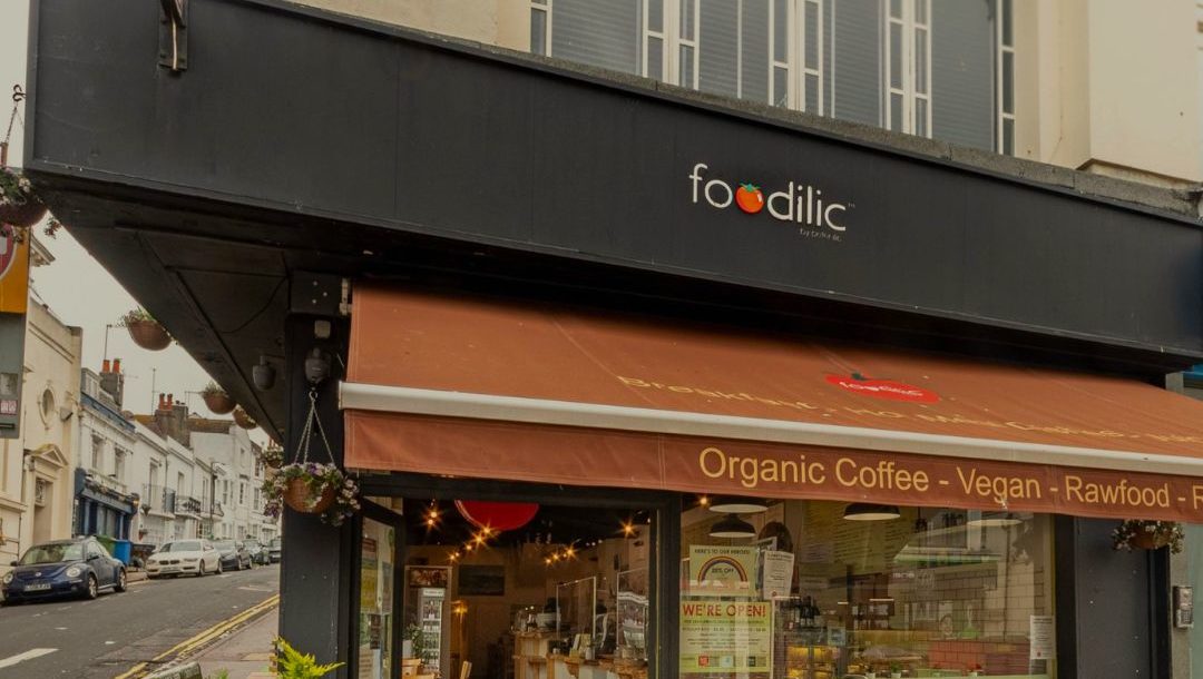 black store exterior which says FOODILIC with a brown cover