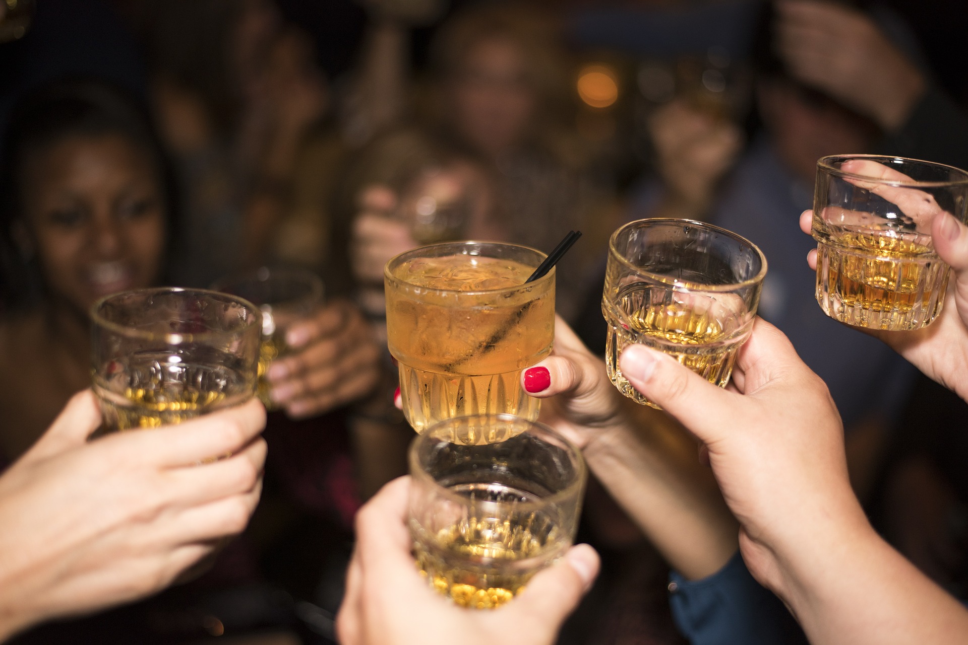 Group of people holding up glasses filled with alcohol