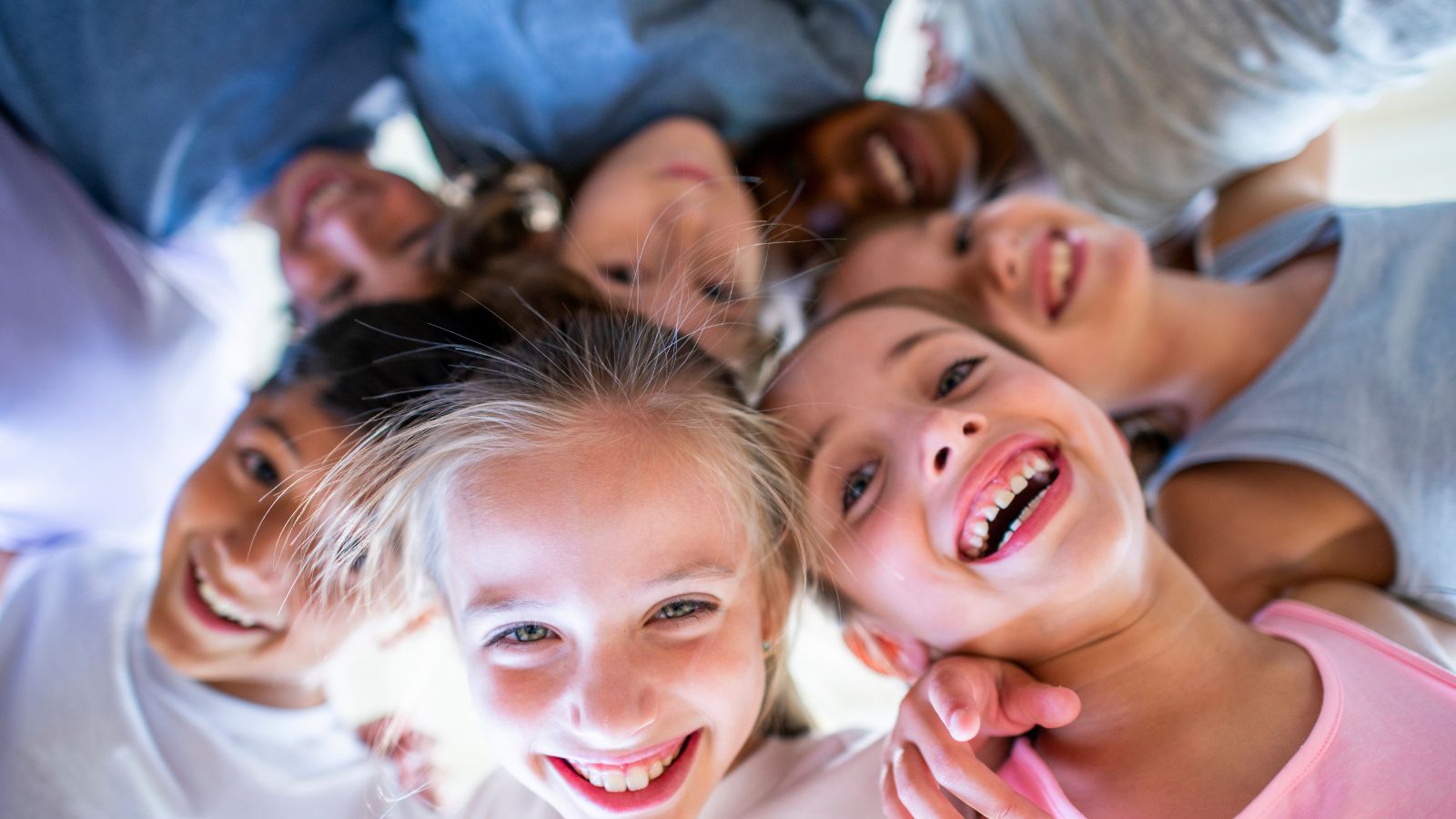 Group of children huddled together in a circle, laughing.