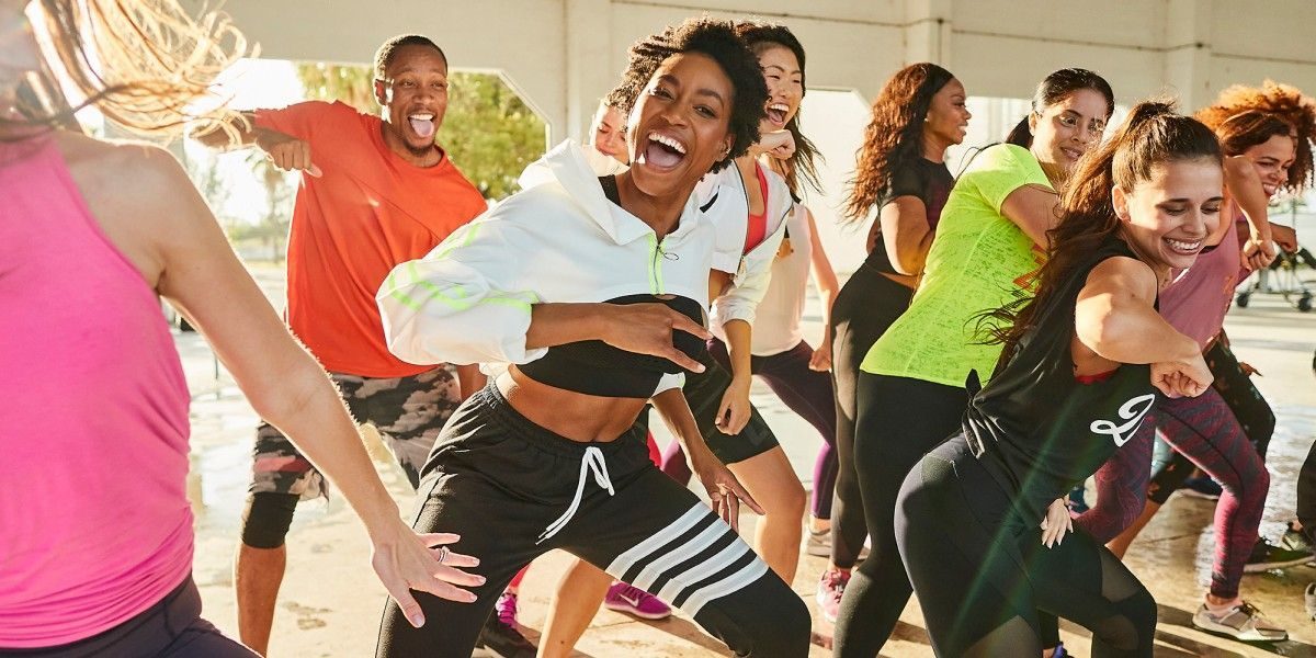 Group of people dressed in gym outfits having fun while dancing