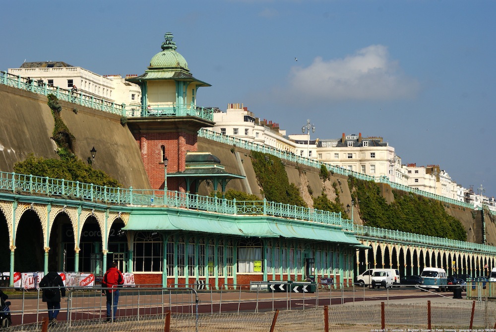 Green banisters in front of cliff above road