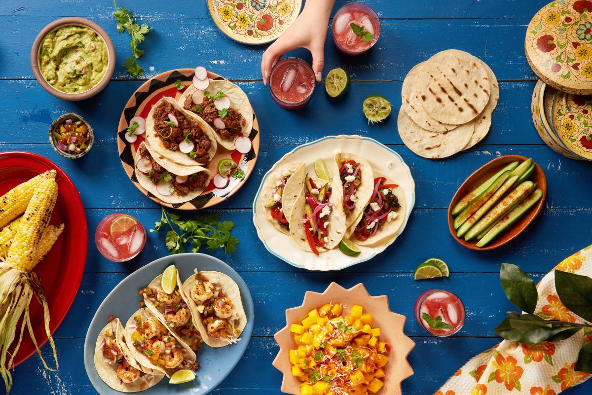 a range of Mexican dishes on blue table