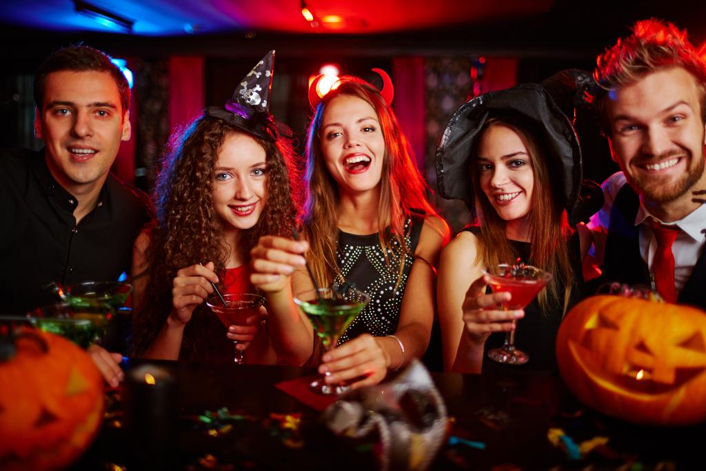people dressed in Halloween costumes holding drinks