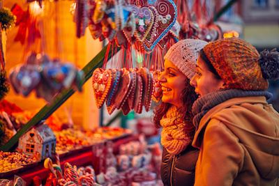 two people looking at items at a stall at a christmas market