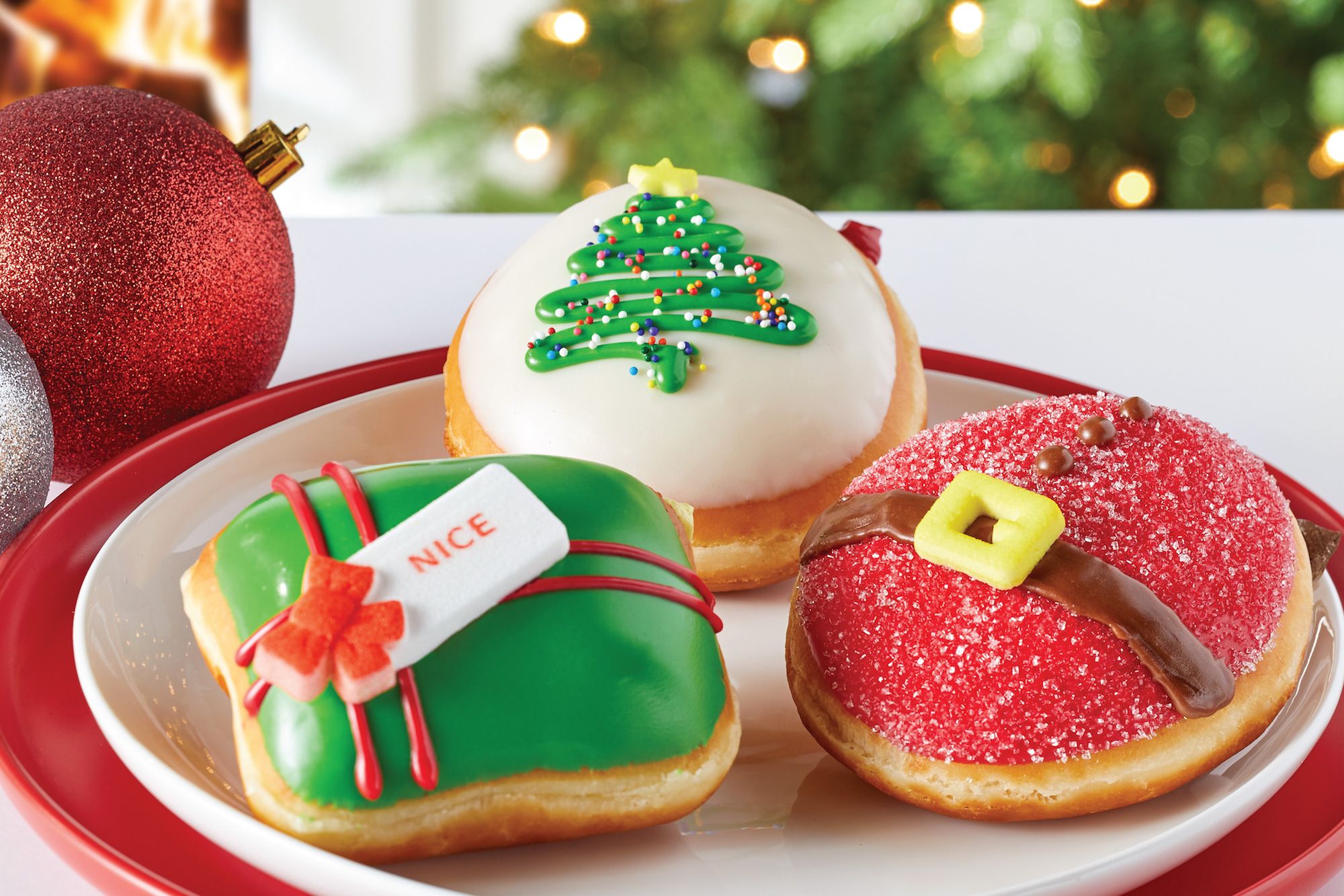 red, white and green glazed donuts on a white plate on table