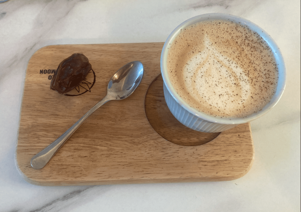 Wooden tray , chai tea latte, metal spoon at Hello My Moon in Brighton
