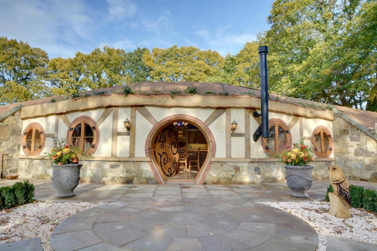 hobbit style glamping house with a round door and round windows, set in stone