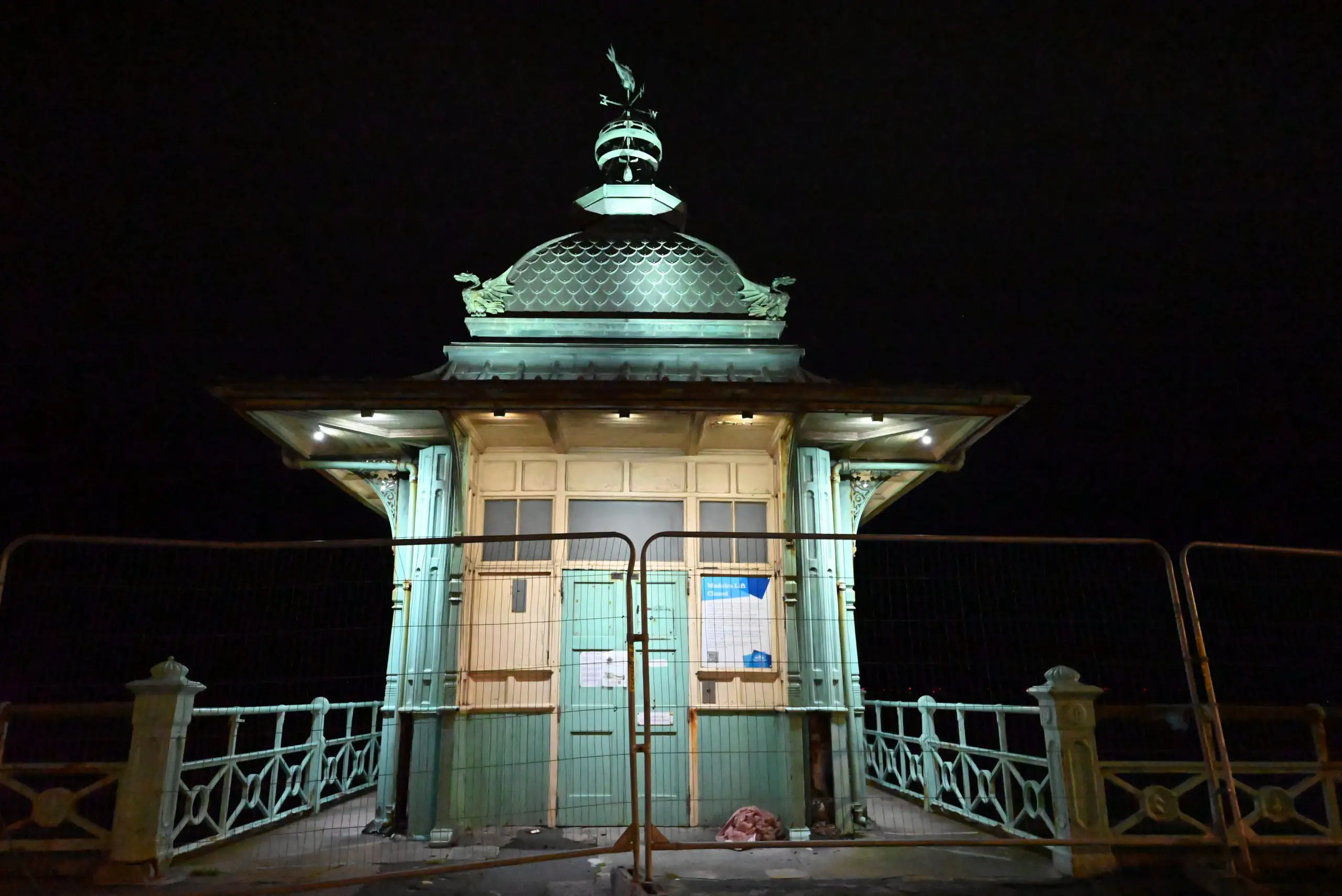 Madeira Lift in Brighton at night, lit up with a barrier around it to indicate closure.